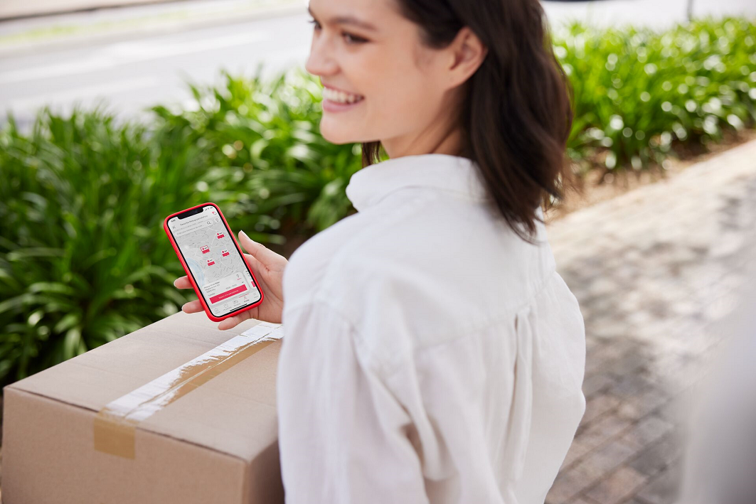 woman with cellphone carrying a parcel