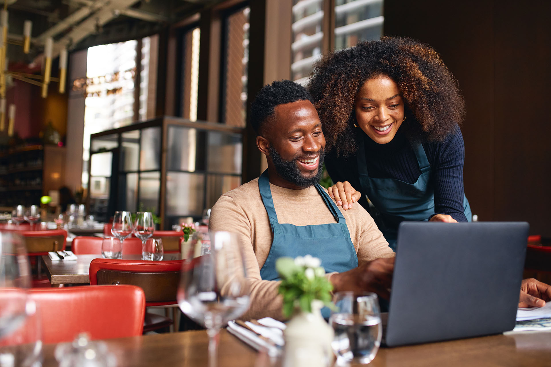 Coppia di ristoratori utilizzano pc all'interno del ristorante